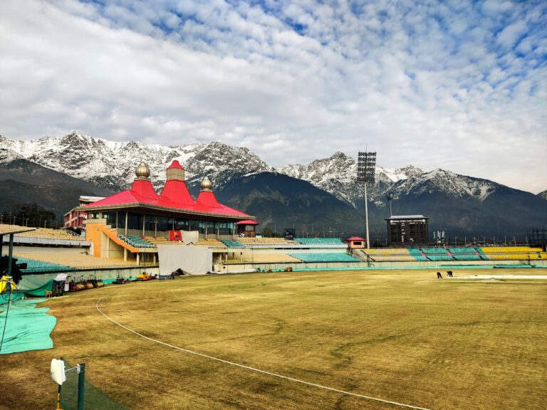 Home Scenic view of Dharamshala Cricket Stadium against stunning snow-capped mountains in Himachal Pradesh, India.